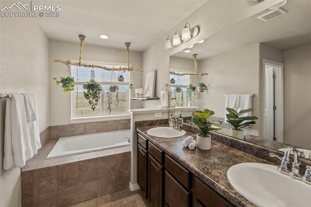 Image 17 of 36: Primary Bathroom featuring a soaking tub, and double vanity
