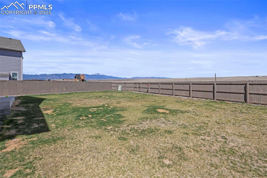 Image 36 of 36: View of yard featuring a mountain view and a fenced backyard
