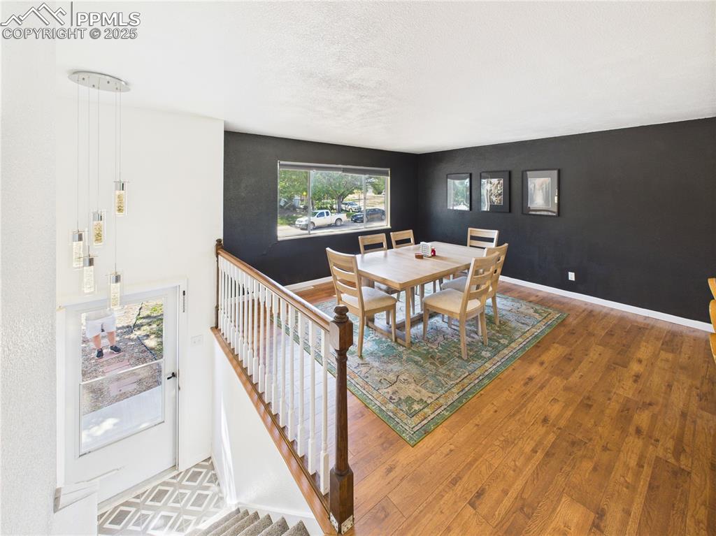Image 16 of 41: Dining space with wood finished floors and an accent wall