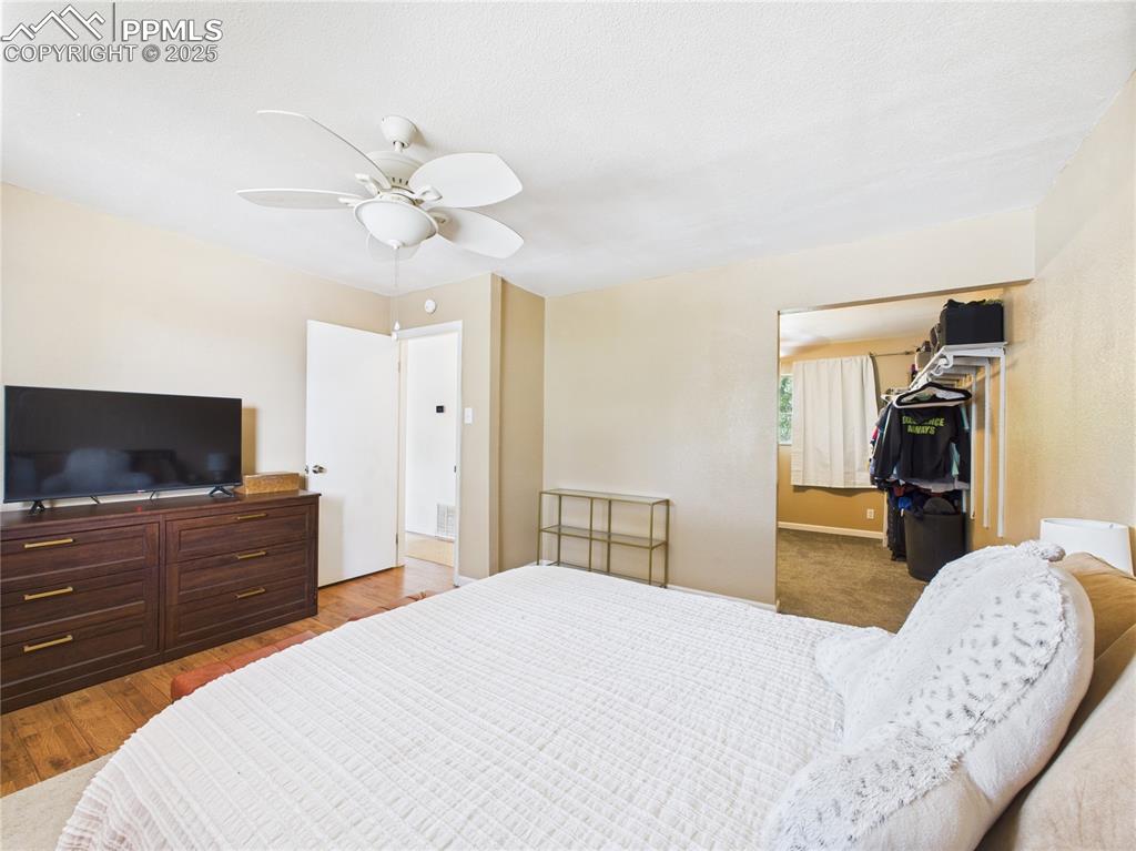 Image 21 of 41: Bedroom featuring wood finished floors, a ceiling fan, a closet, and a spac