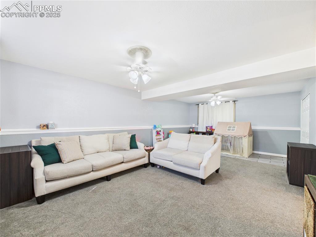 Image 32 of 41: Carpeted living room with ceiling fan and baseboards