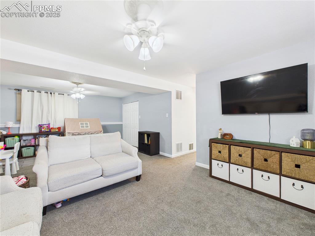 Image 33 of 41: Carpeted living area with ceiling fan