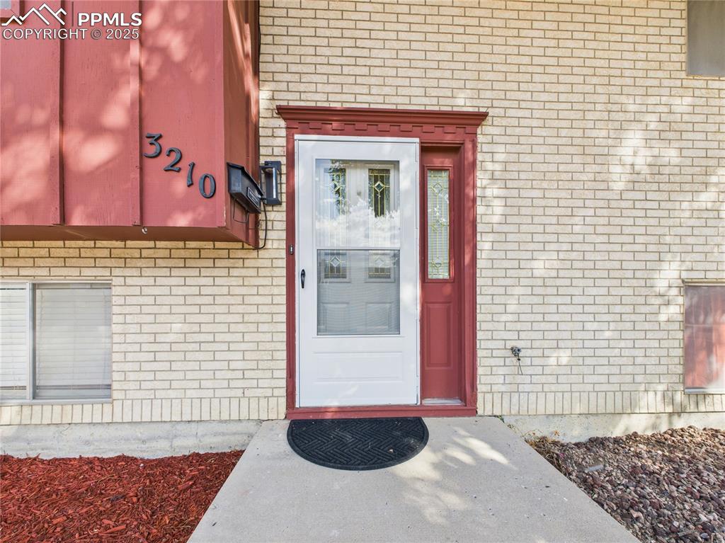 Image 4 of 41: Doorway to property with brick siding