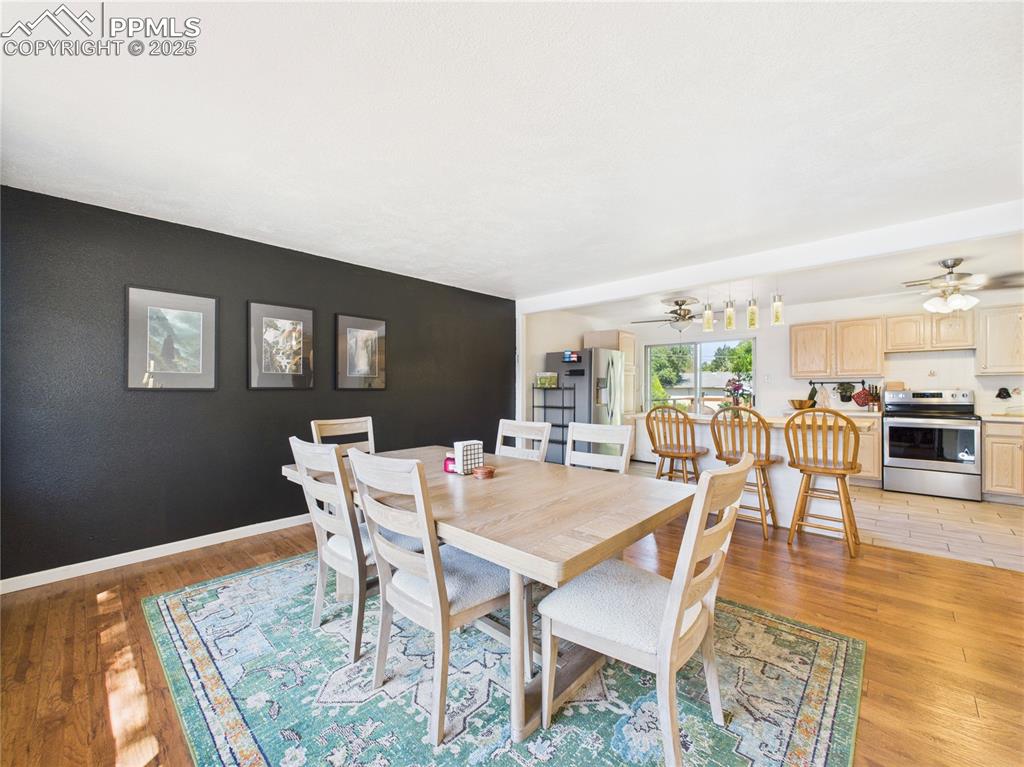 Image 5 of 41: Dining room featuring ceiling fan, light wood-style floors, and an accent w