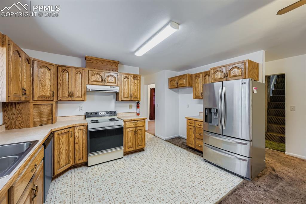 Image 10 of 28: Kitchen featuring stainless steel refrigerator with ice dispenser, brown ca