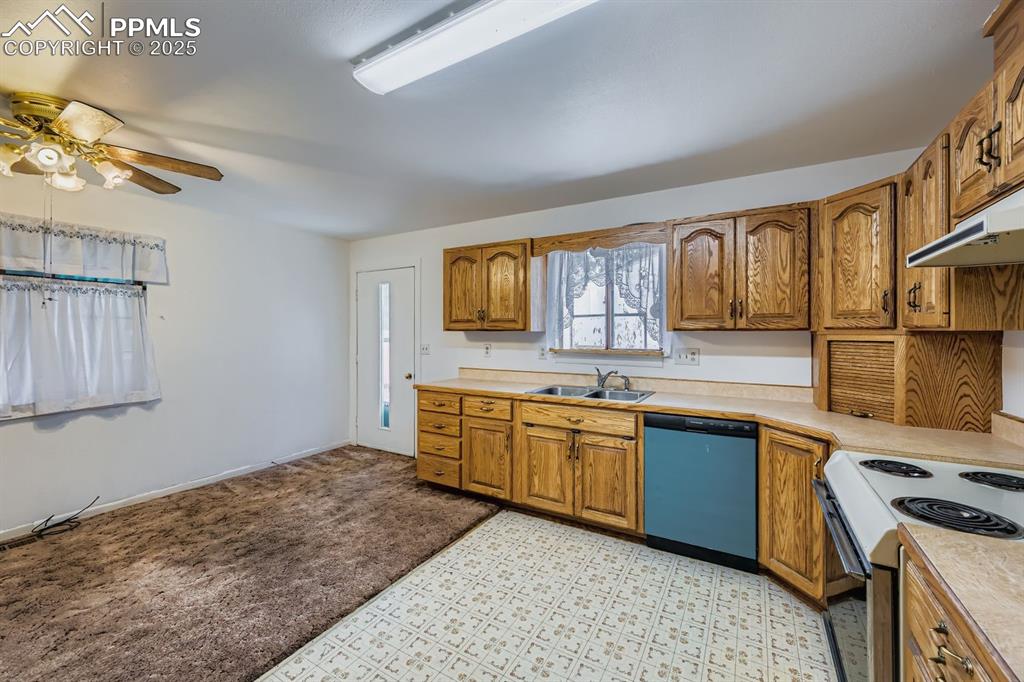 Image 11 of 28: Kitchen featuring brown cabinets, white electric stove, light countertops,