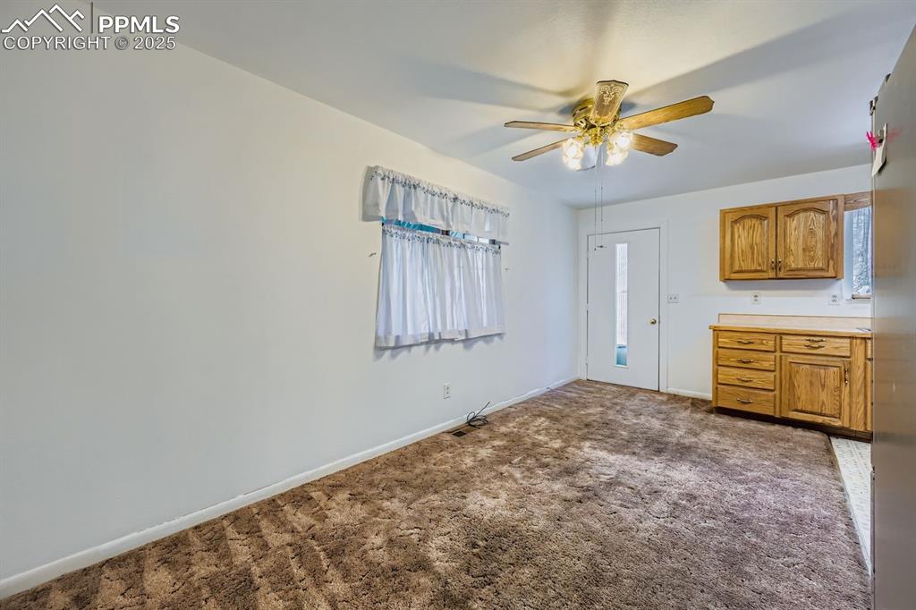 Image 12 of 28: Kitchen with dark carpet, brown cabinetry, light countertops, stainless ste