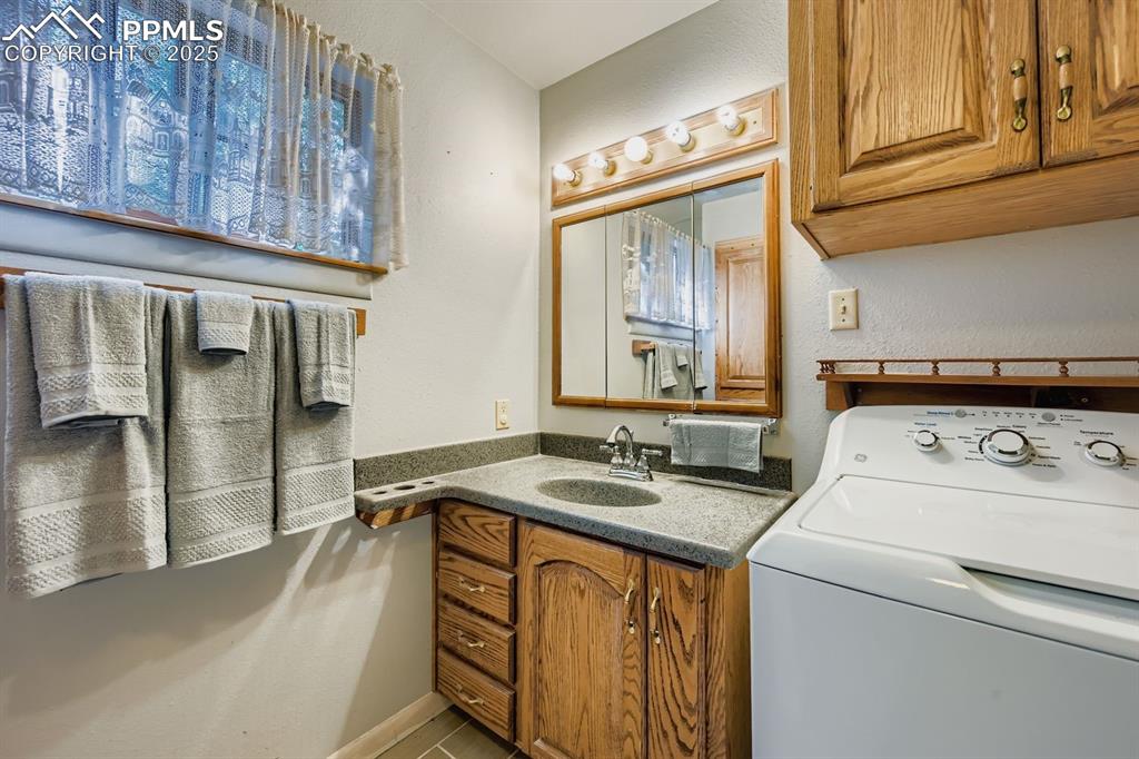 Image 17 of 28: Full bath featuring washer / clothes dryer, vanity, and a textured wall