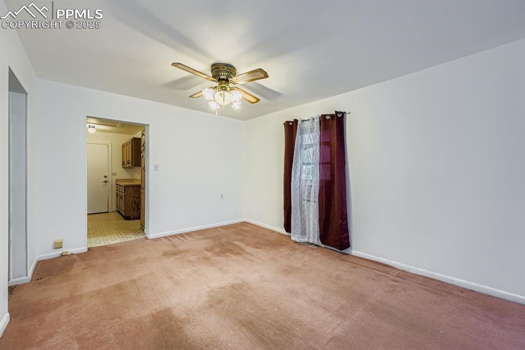 Image 18 of 28: Unfurnished room with light carpet, attic access, and a ceiling fan