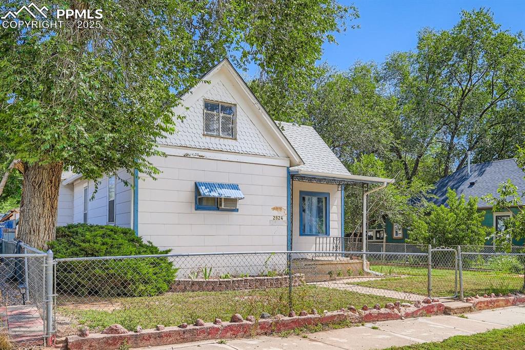 Image 2 of 28: View of front of property featuring a fenced front yard, a gate, and a porc