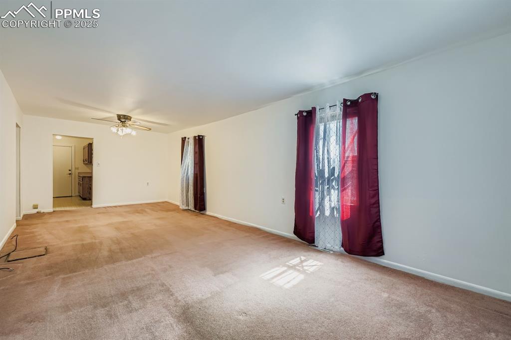 Image 7 of 28: Unfurnished room with carpet and ceiling fan