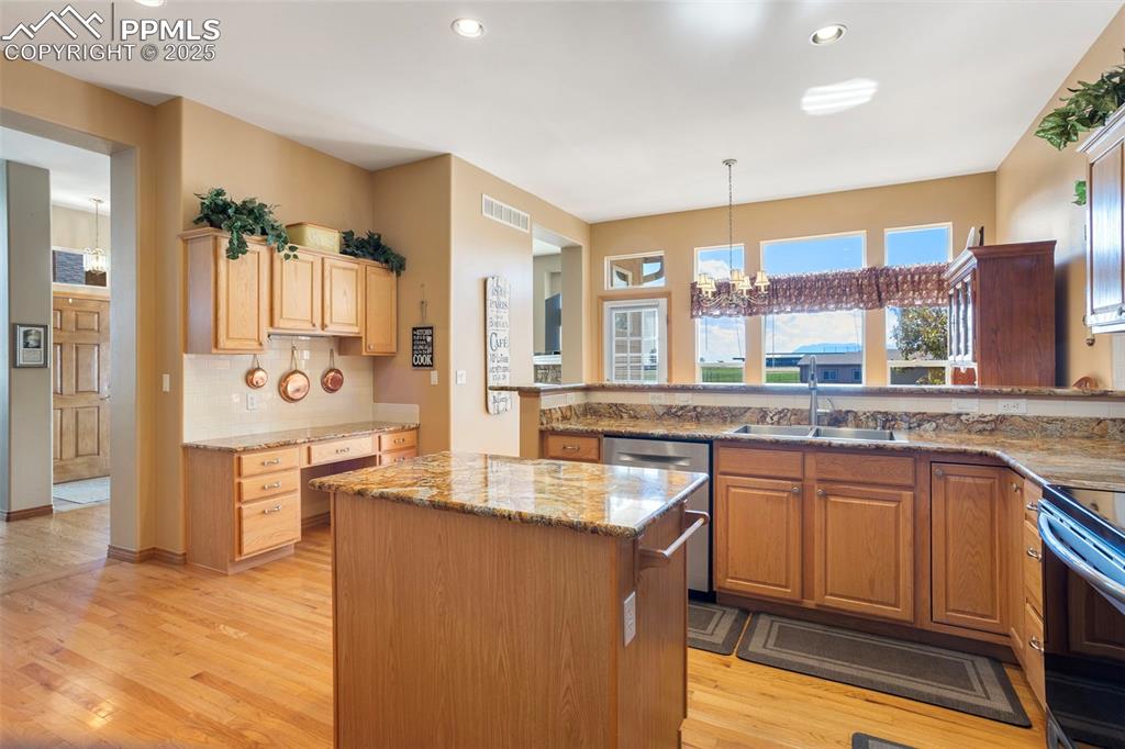 Image 11 of 33: The kitchen includes a desk/workstation with granite countertop and additio