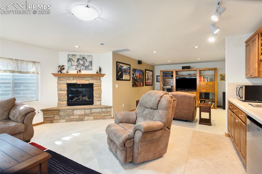 Image 20 of 33: The huge basement family room is highlighted by a stone gas fireplace and w