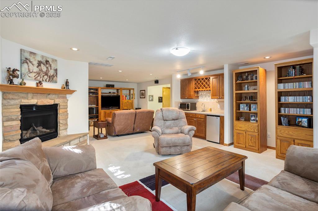 Image 22 of 33: Basement family room includes a convenient wet bar with mini fridge.
