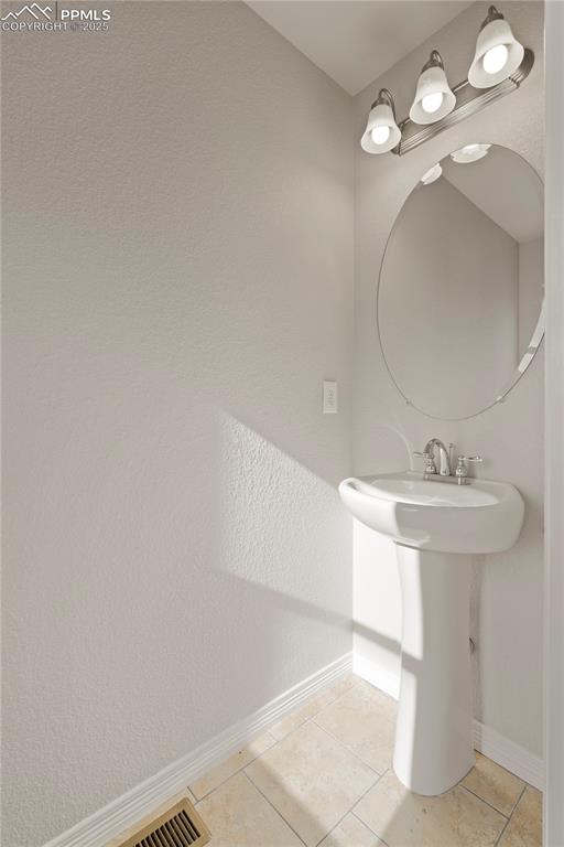 Image 12 of 35: Bathroom featuring light tile patterned flooring and a textured wall