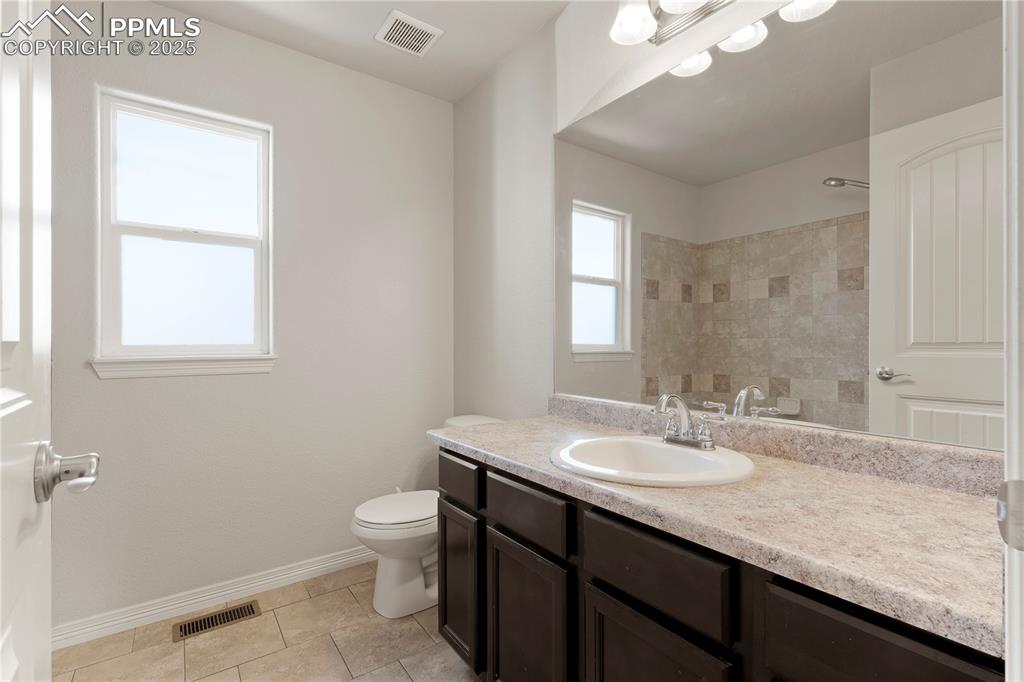 Image 14 of 35: Bathroom with vanity, a shower, and light tile patterned floors