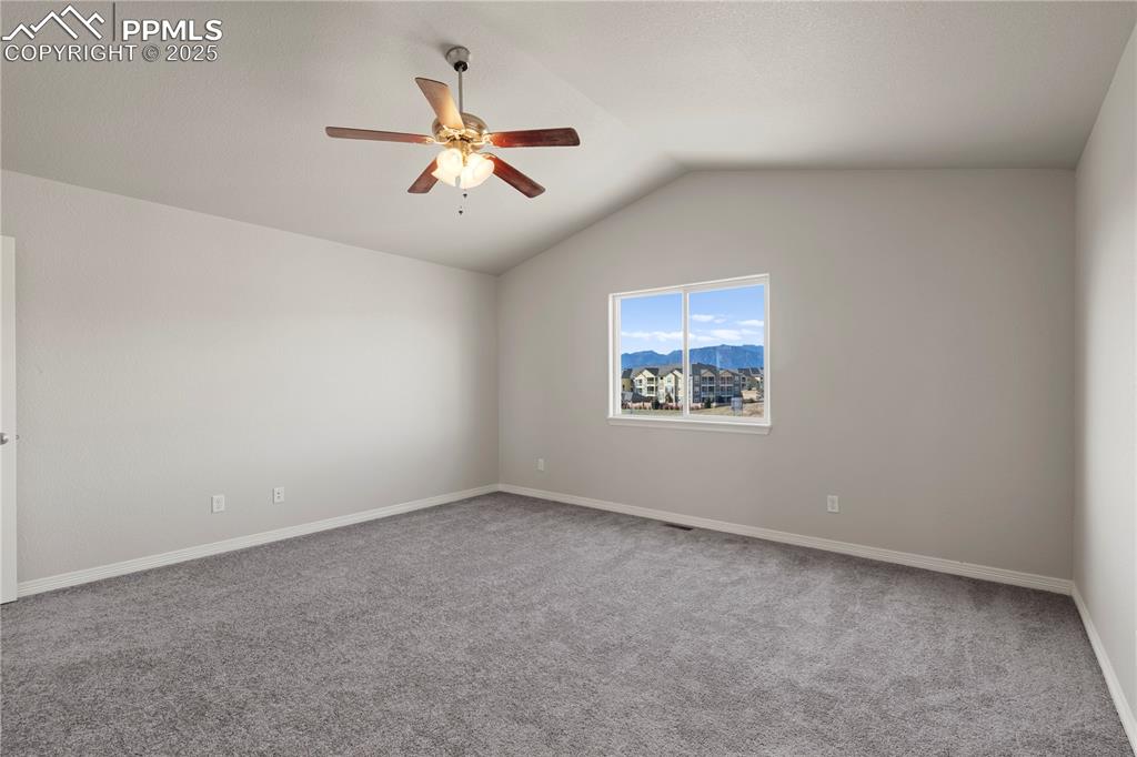 Image 18 of 35: Empty room featuring lofted ceiling, light colored carpet, a mountain view,
