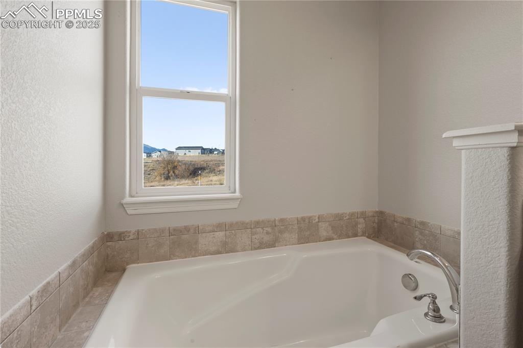 Image 21 of 35: Full bath featuring a garden tub and a textured wall