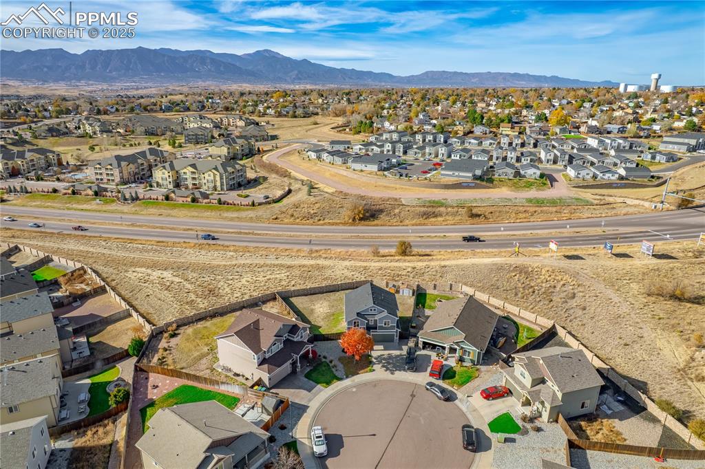 Image 31 of 35: Aerial view of residential area with a mountainous background