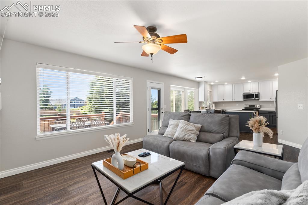 Image 14 of 31: Living room with ceiling fan, dark wood-type flooring, and recessed lightin