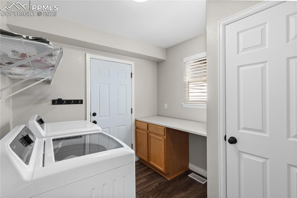 Image 16 of 31: Washroom featuring washer and dryer and dark wood-style flooring