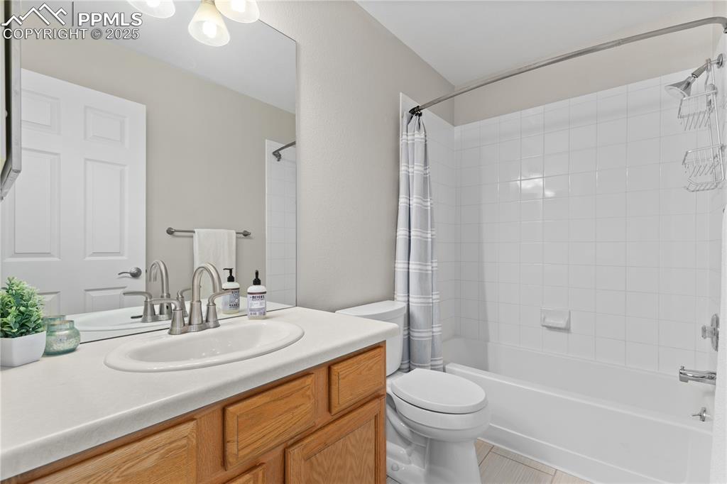 Image 21 of 31: Full bath with shower / bath combo, vanity, and tile patterned flooring