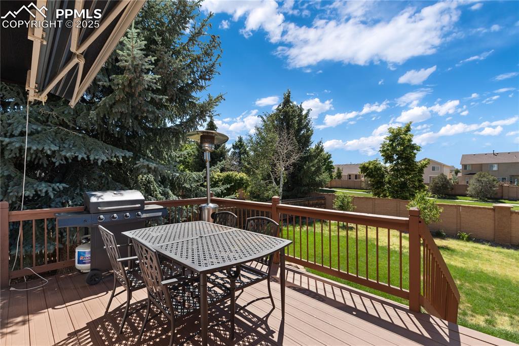 Image 27 of 31: Wooden terrace with outdoor dining area and grilling area