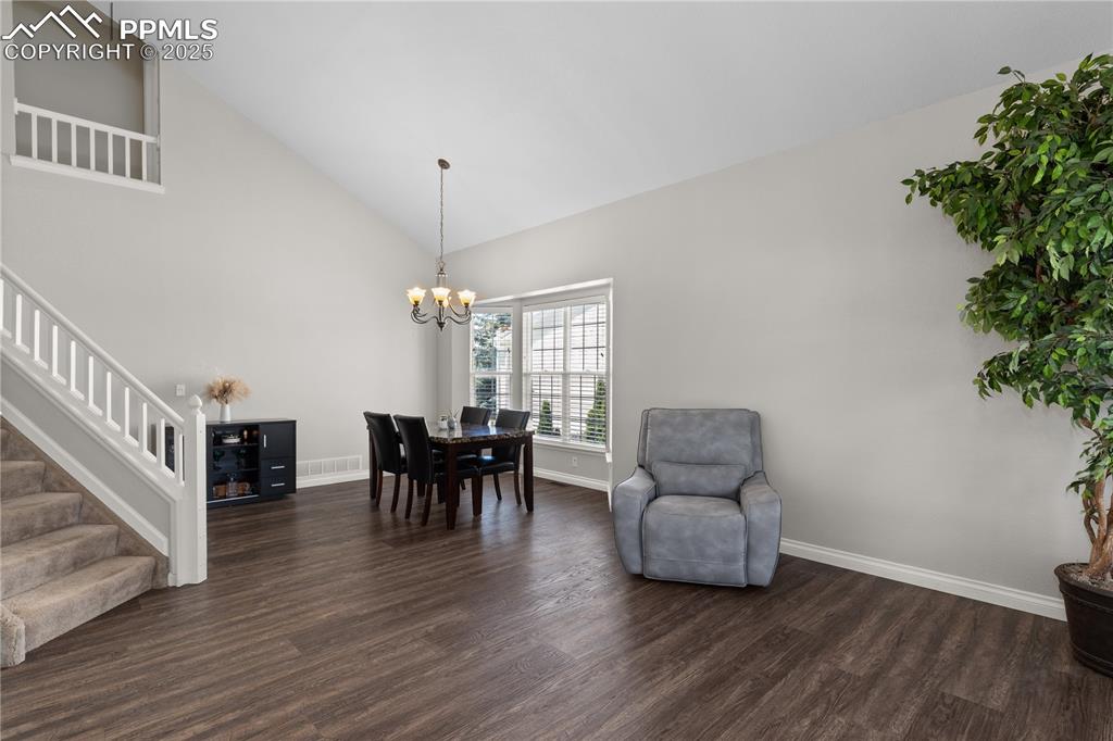 Image 3 of 31: Living area featuring stairs, dark wood-type flooring, a chandelier, and hi