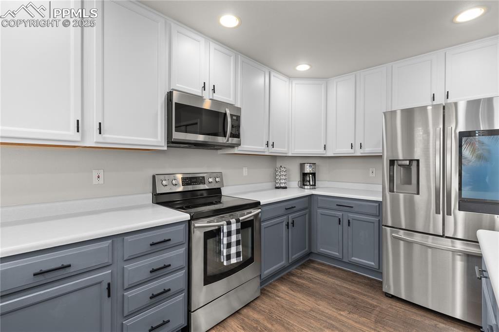Image 9 of 31: Kitchen featuring gray cabinets, stainless steel appliances, light countert