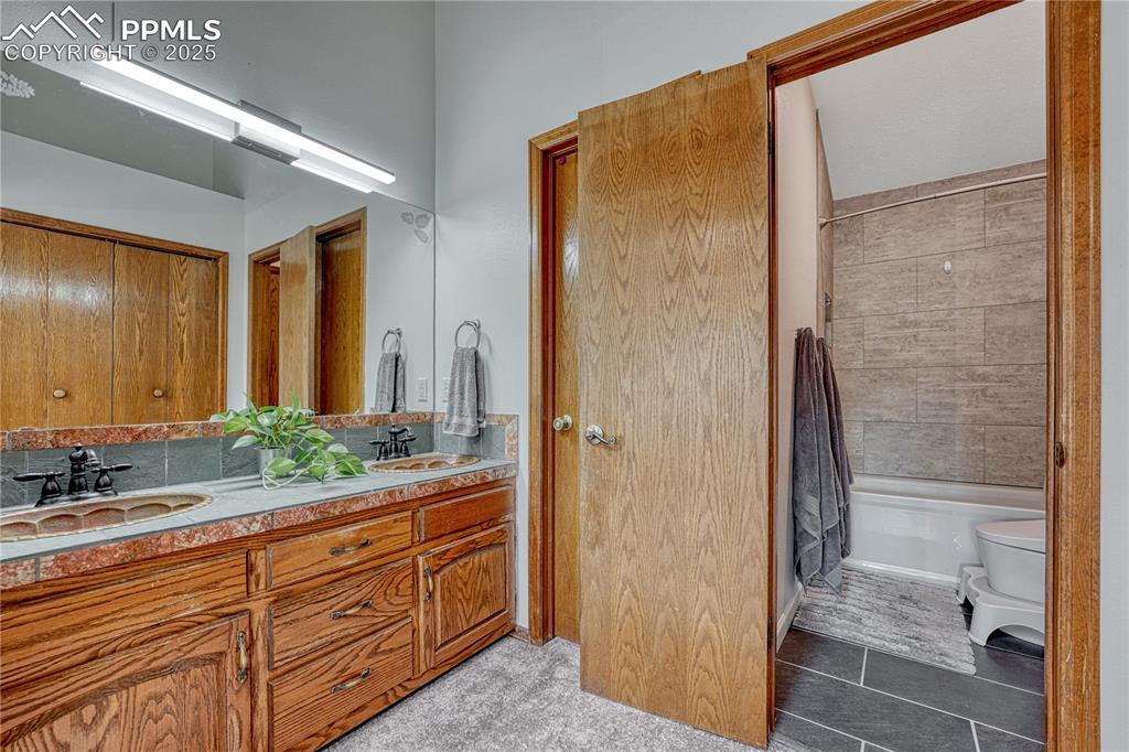 Image 15 of 48: Primary bedroom bathroom with walk-in closet, double vanities, copper wash