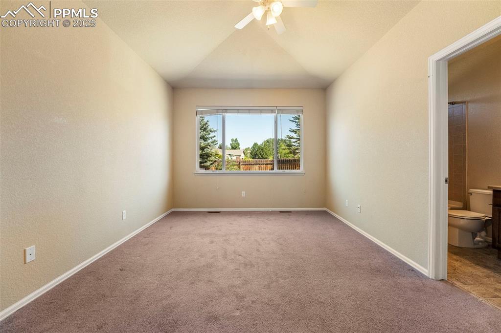 Image 17 of 49: Unfurnished room with ceiling fan, carpet flooring, and vaulted ceiling