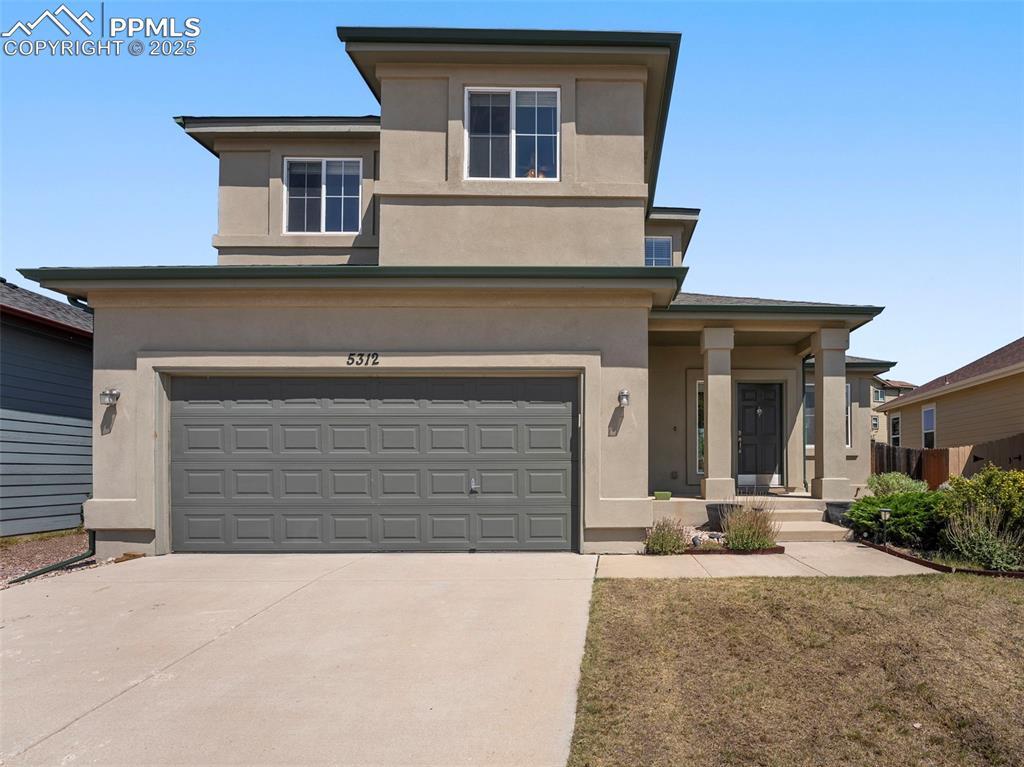 Image 2 of 49: Prairie-style home featuring stucco siding, driveway, and an attached garag