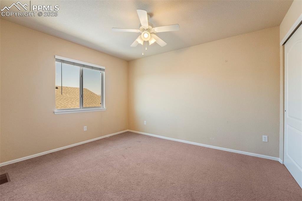 Image 24 of 49: Carpeted spare room with a ceiling fan and baseboards