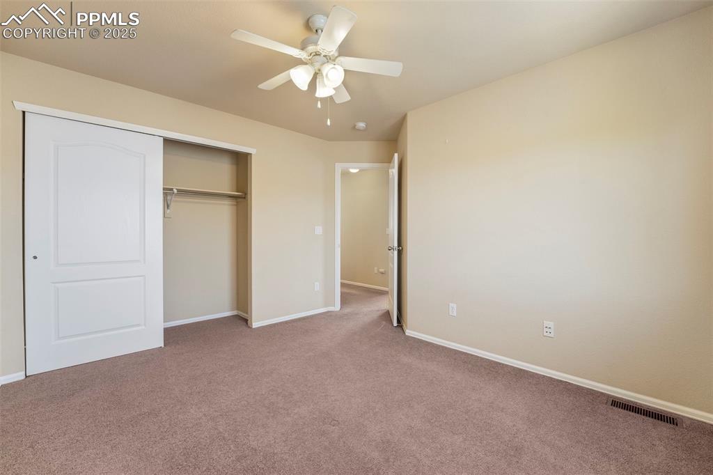 Image 25 of 49: Unfurnished bedroom featuring carpet flooring, a closet, and a ceiling fan
