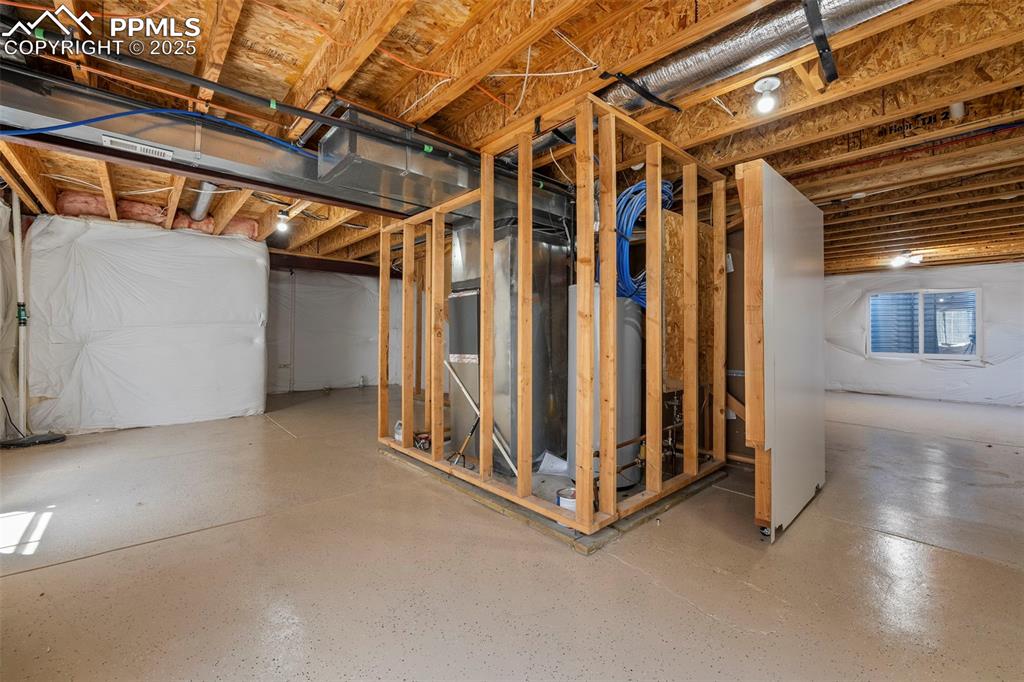 Image 29 of 49: Unfinished below grade area featuring water heater and heating unit