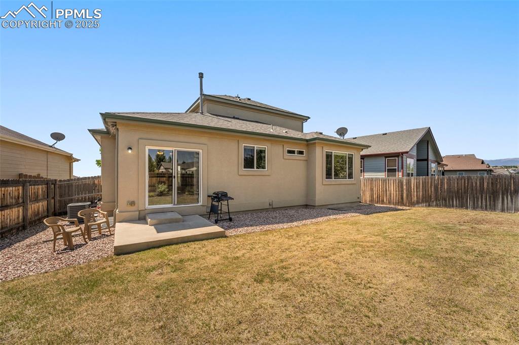 Image 38 of 49: Rear view of house with a fenced backyard and a patio area