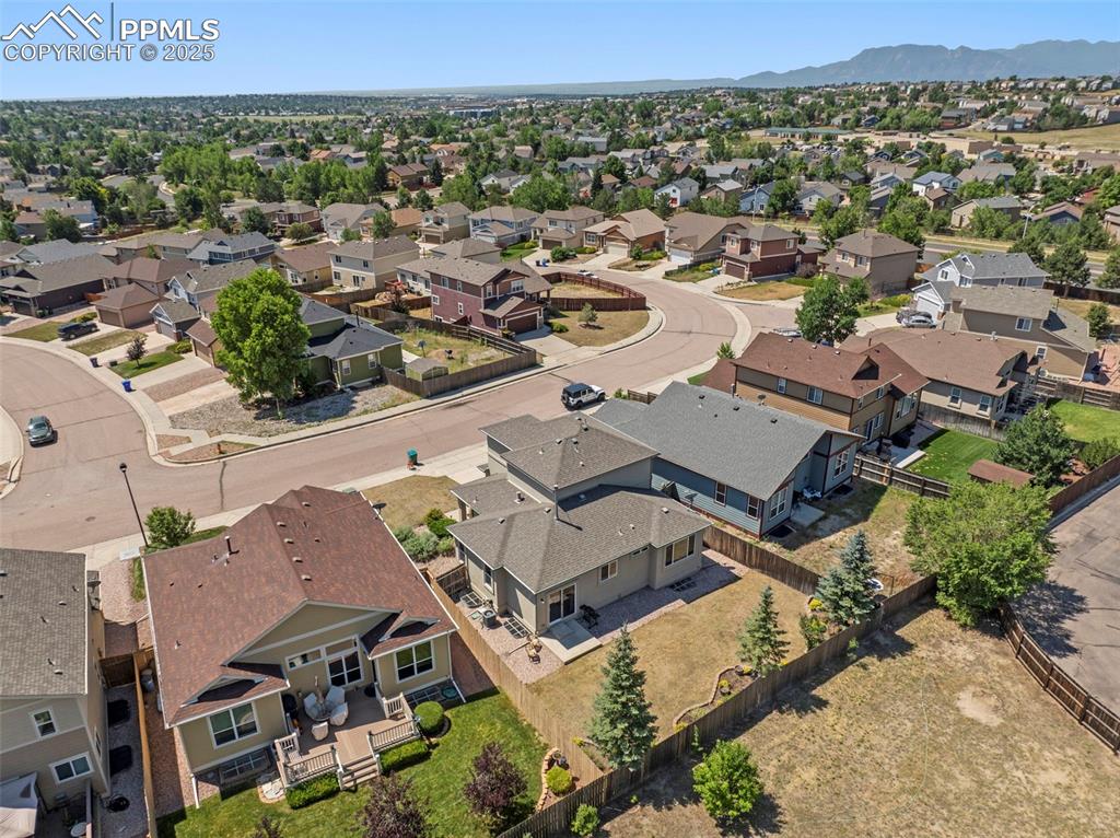 Image 49 of 49: Aerial view of residential area featuring a mountainous background