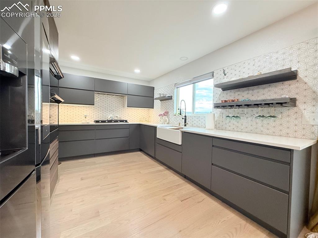 Image 17 of 47: Kitchen with open shelves, modern cabinets, gray cabinetry, light wood fini