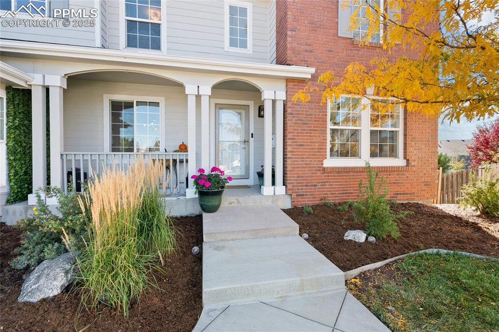 Image 2 of 47: Doorway to property featuring brick siding and a porch