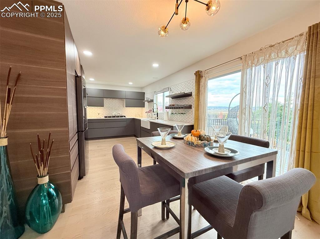 Image 20 of 47: Dining area with light wood finished floors and recessed lighting