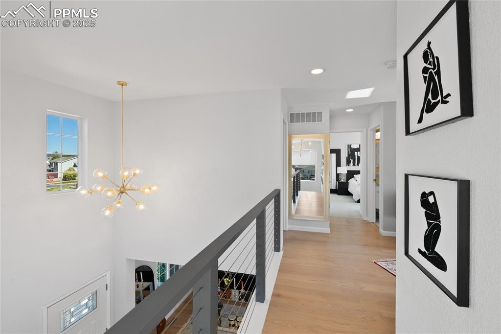 Image 22 of 47: Hallway featuring recessed lighting, light wood-style flooring, a chandelie