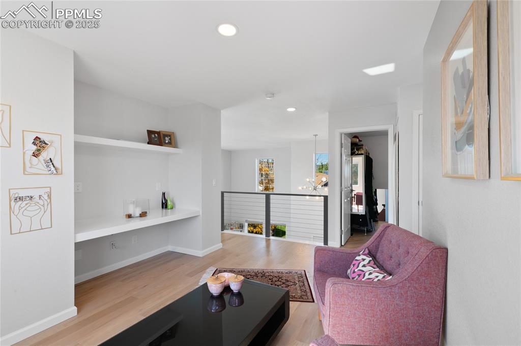 Image 27 of 47: Living area with recessed lighting, light wood-type flooring, and a chandel