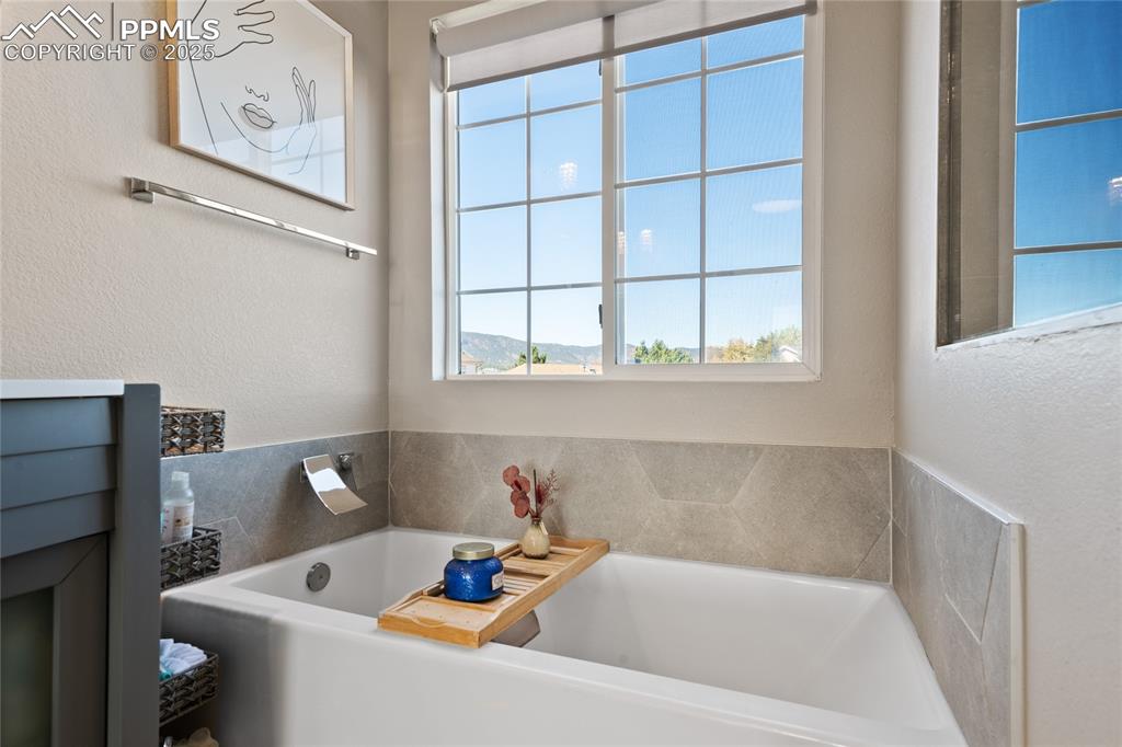 Image 34 of 47: Bathroom with a garden tub and a textured wall