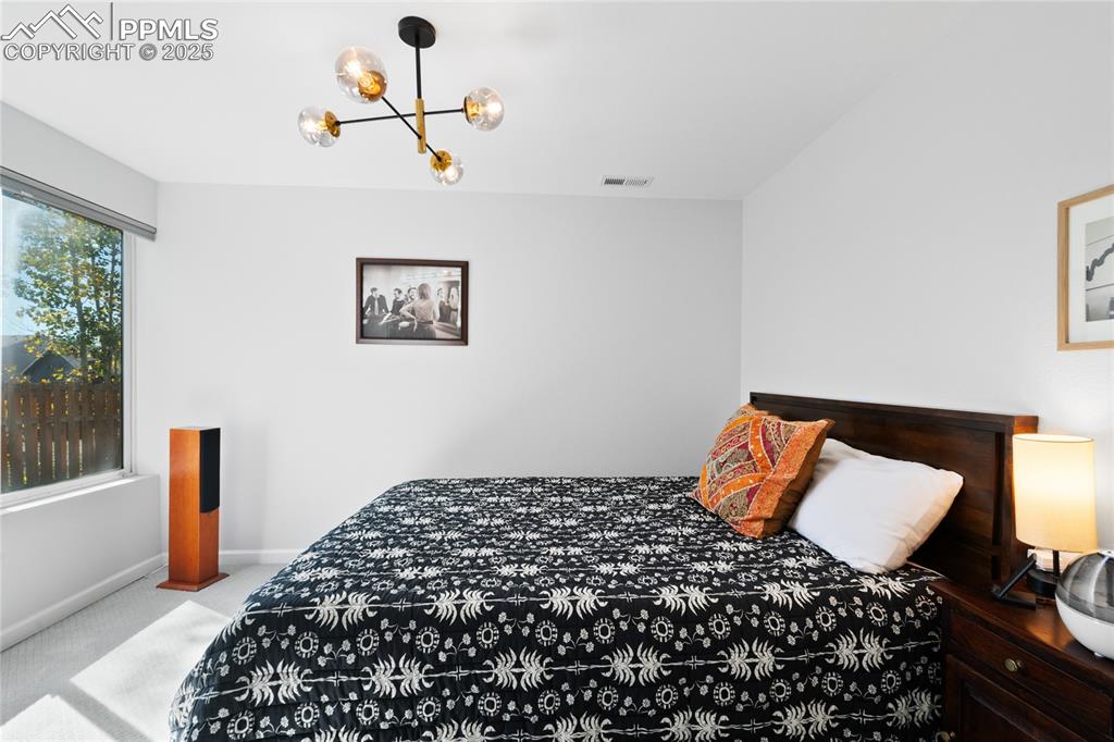Image 37 of 47: Carpeted bedroom featuring a chandelier and baseboards
