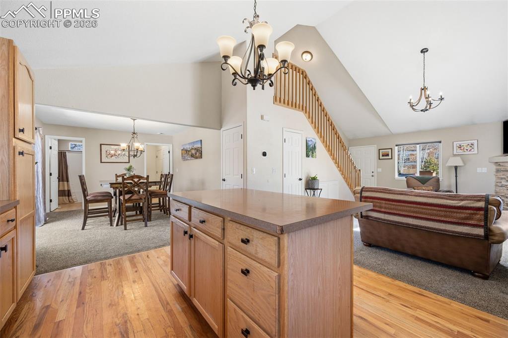 Image 13 of 36: Main level kitchen with open concept to living room and dining area
