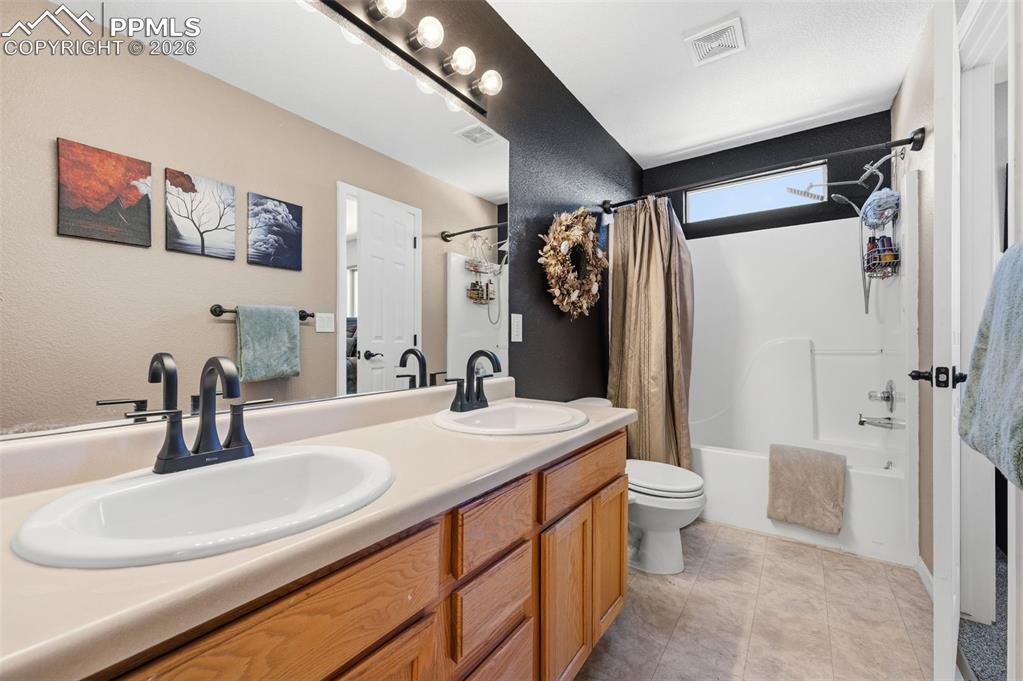 Image 18 of 36: Upper level shared full bathroom with access to primary and