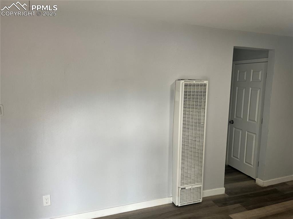 Image 21 of 26: Unfurnished room with a heating unit and dark wood finished floors