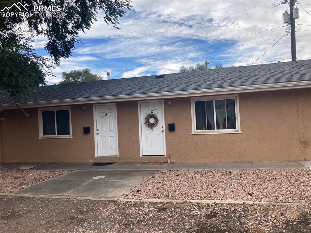 Image 9 of 26: Property entrance with stucco siding and roof with shingles