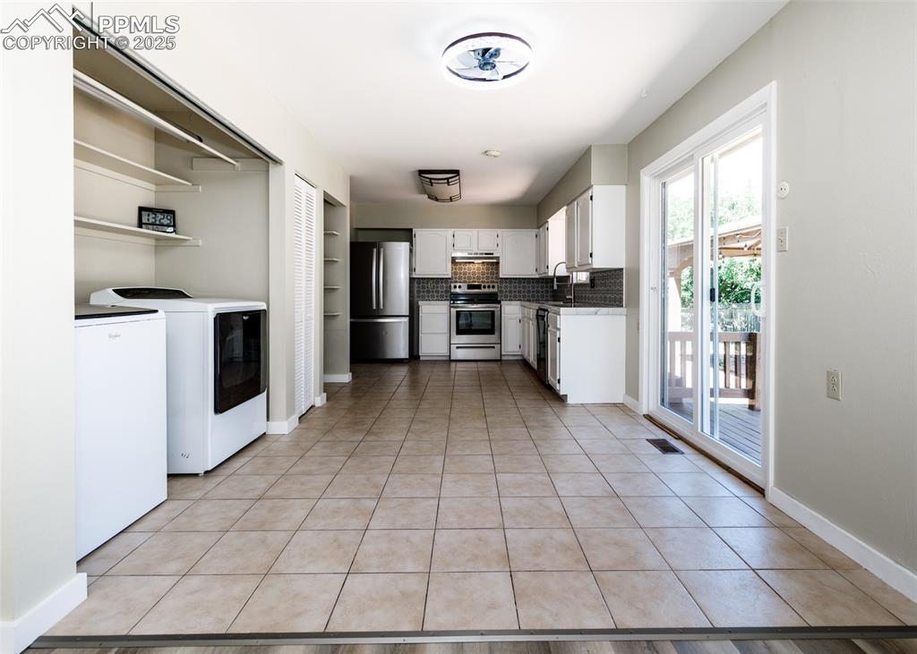 Image 18 of 48: Kitchen featuring white cabinetry, open shelves, backsplash, and light tile