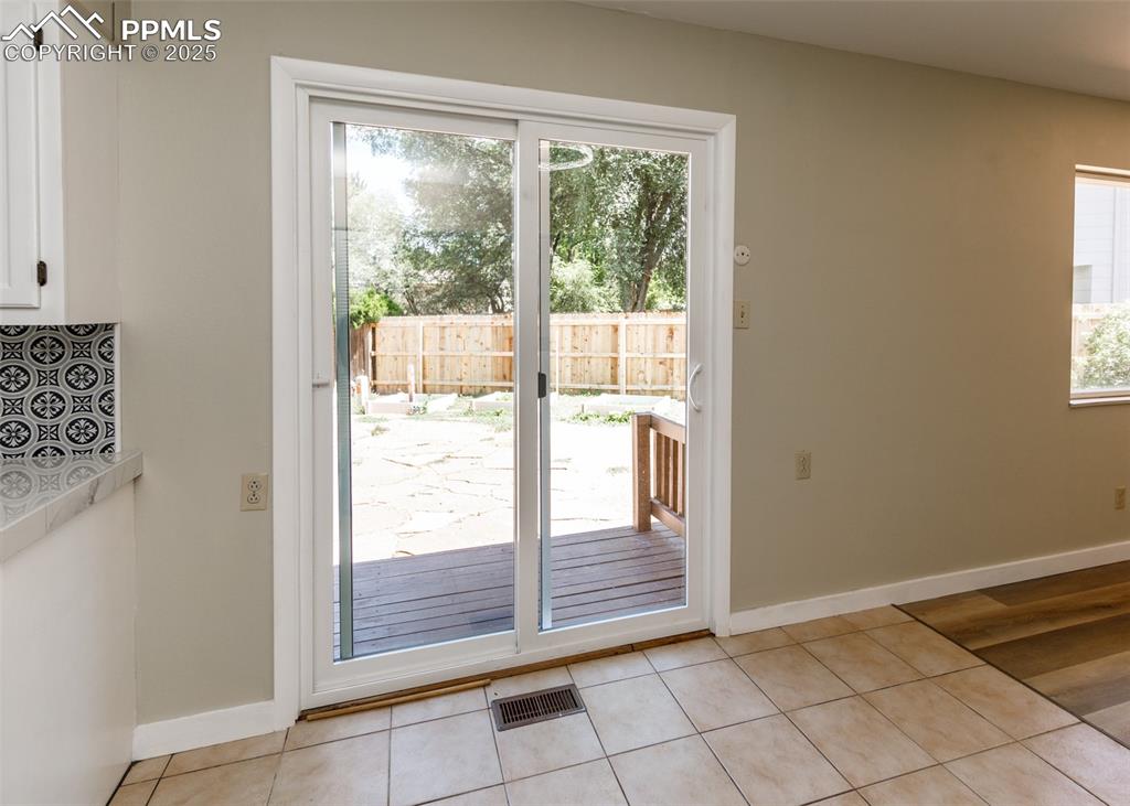 Image 21 of 48: Doorway with tile patterned floors and baseboards